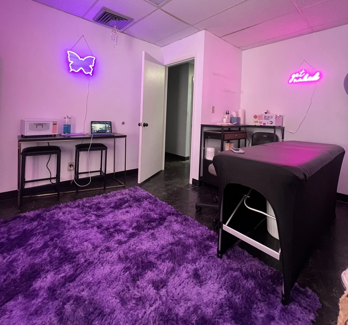 The Flutter Club private treatment room with purple accents and a waxing bed